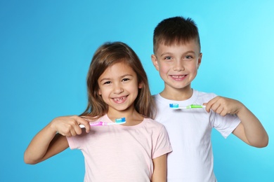 Portrait of cute children with toothbrushes on color background