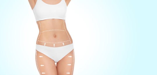 Slim young woman with marks on body for cosmetic surgery operation against light background, closeup. Banner design