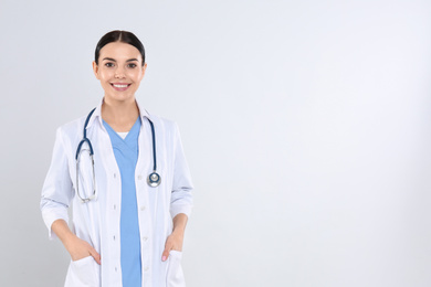 Photo of Portrait of young doctor with stethoscope on white background