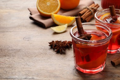 Aromatic punch drink and ingredients on wooden table, space for text