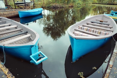 Old light blue wooden boats on lake