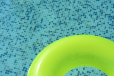 Light green inflatable ring floating in swimming pool, top view. Space for text