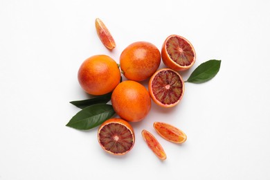 Ripe sicilian oranges and leaves on white background, flat lay