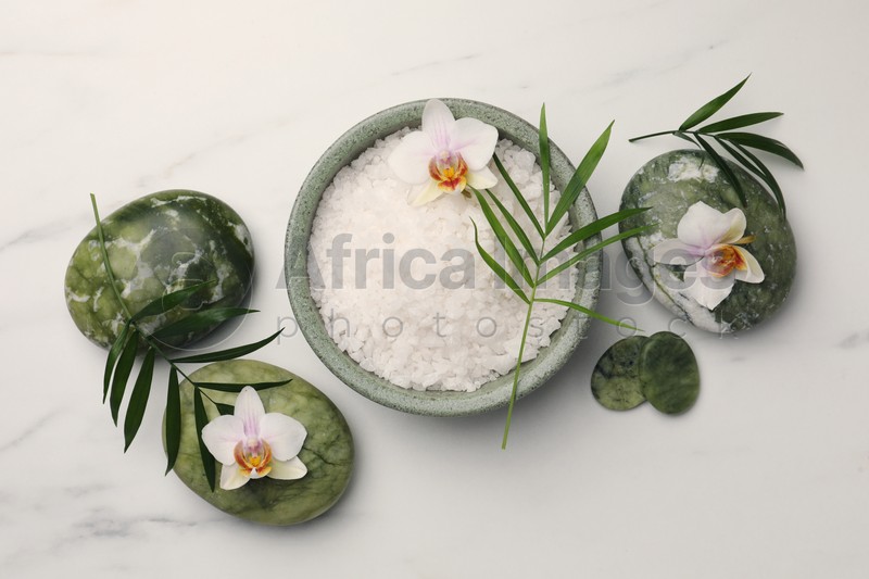 Photo of Flat lay composition with spa products and flowers on white marble table