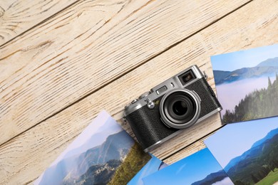 Vintage photo camera and beautiful printed pictures on wooden table, flat lay with space for text. Creative hobby