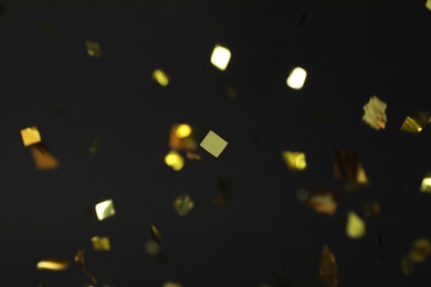 Shiny golden confetti falling down on black  background