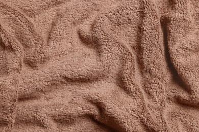 Soft crumpled brown towel as background, top view