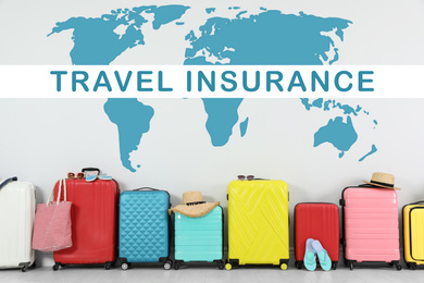 Colorful suitcases and phrase TRAVEL INSURANCE on light background
