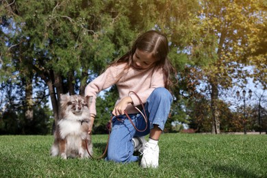 Photo of Little girl with her cute dog in park. Autumn walk