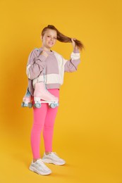 Cute indie girl with roller skates on yellow background