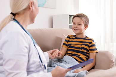 Family doctor visiting ill child at home