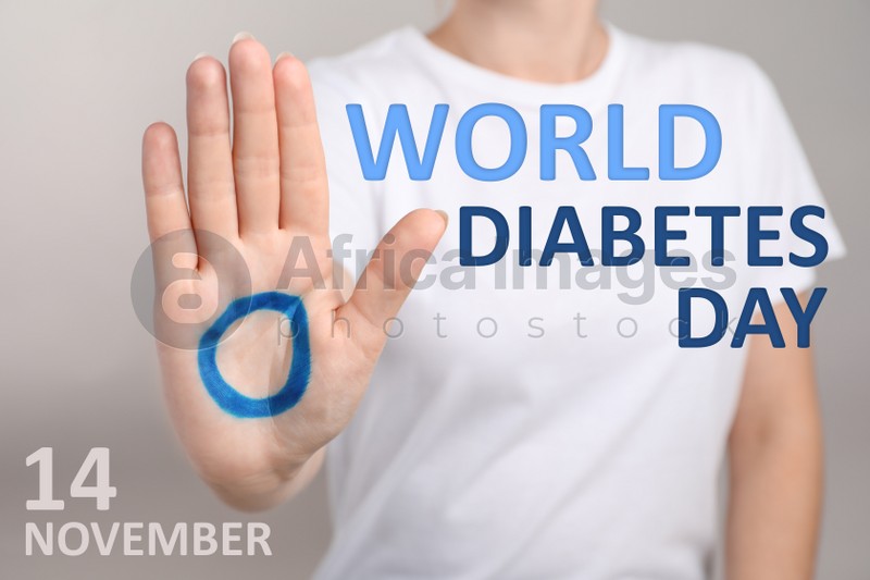 Woman showing blue circle drawn on palm against light background, closeup. World Diabetes Day