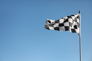 Checkered finish flag on light blue background. Space for text