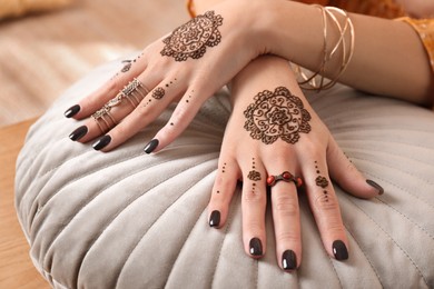 Woman with henna tattoos on hands, closeup. Traditional mehndi ornament