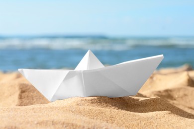 White paper boat near sea on sunny day, closeup