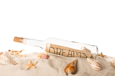Corked glass bottle with Dreams note and seashells on sand against white background