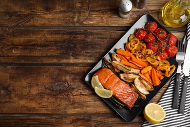 Photo of Tasty cooked salmon and vegetables served on wooden table, flat lay with space for text. Healthy meals from air fryer