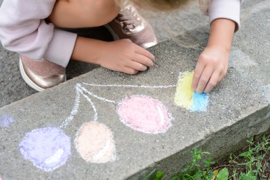 Little child drawing balloons and ukrainian flag with chalk on curb outdoors, closeup
