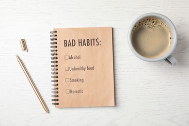 Image of Notebook with list of bad habits, pen and cup of coffee on white wooden table, flat lay. Change your lifestyle