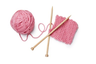Soft pink woolen yarn, knitting and wooden needles on white background, top view