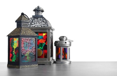 Decorative Arabic lanterns on grey table against white background