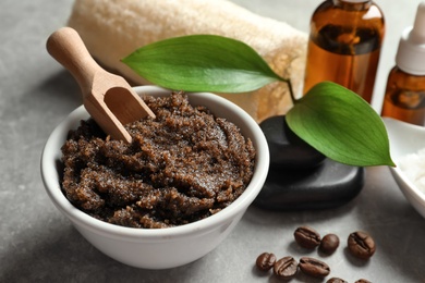 Bowl of coffee scrub with scoop on table