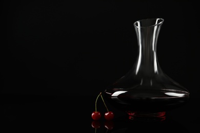Delicious cherry wine and ripe juicy berries on black background. Space for text