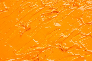 Beautiful strokes of orange oil paint as background, closeup