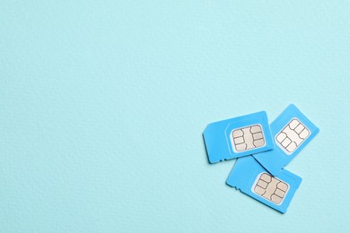 Color SIM cards on turquoise background, flat lay. Space for text