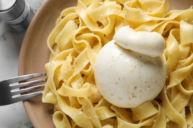 Delicious pasta with burrata cheese on white table, top view