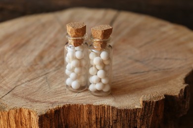 Bottles with homeopathic remedy on wooden stump