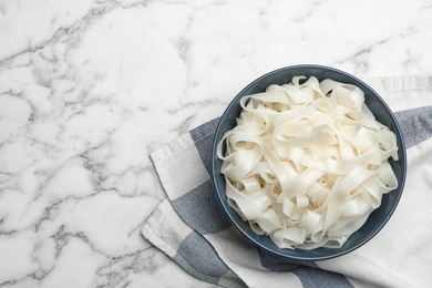 Rice noodles on white marble table, flat lay. Space for text