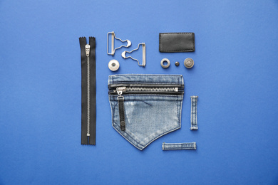 Photo of Flat lay composition with garment accessories and cutting details for jeans on blue background