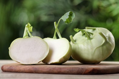 Whole and cut kohlrabi plants on wooden table