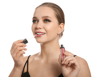 Beautiful woman applying lip gloss on white background. Stylish makeup