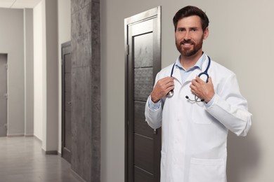 Doctor in white coat with stethoscope indoors. Space for text