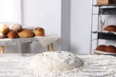 Photo of Fresh dough with flour on table in kitchen
