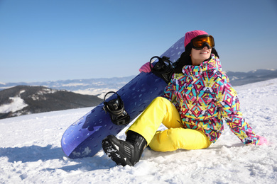 Young woman with snowboard on hill. Winter vacation
