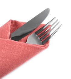 Fork and knife wrapped in coral napkin on white background, top view