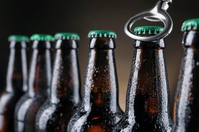 Photo of Opening bottle of beer on dark background, closeup. Space for text