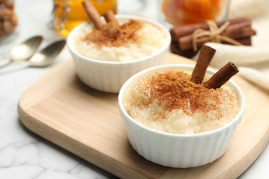 Delicious rice pudding with cinnamon on wooden board
