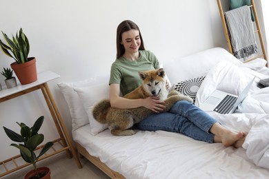 Image of Happy woman with her cute Akita Inu puppy at home
