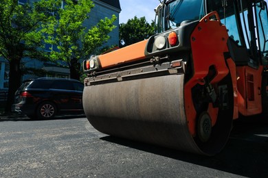 Roller working on city street, low angle view. Road repairing