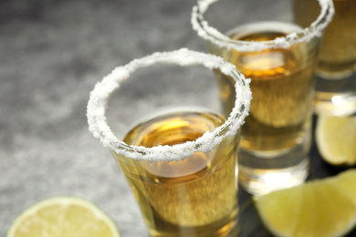 Mexican Tequila shots with salt on grey table, closeup