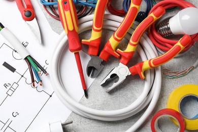 Photo of Set of electrician's tools and accessories on grey background
