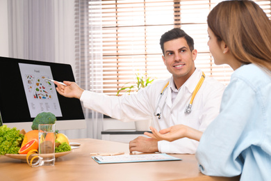 Nutritionist consulting patient at table in clinic