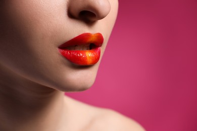 Young woman with beautiful lips makeup on pink background, closeup. Space for text