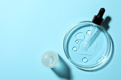 Photo of Petri dish, pipette and bottle on light blue background, flat lay. Space for text