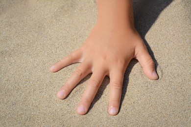 Child leaving handprint on sand outdoors, closeup. Fleeting time concept