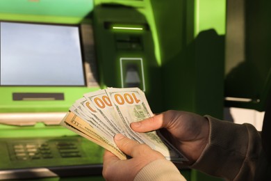 Man with money near cash machine, closeup